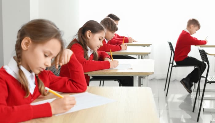 a group of children sitting at desks in a classroom